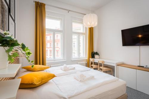 a bedroom with a large white bed with yellow pillows at Self-service Hotel Ostaš Praha in Prague