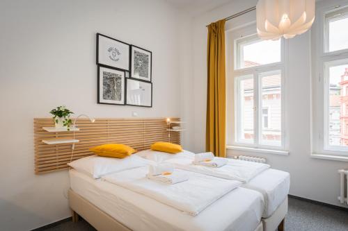 a bedroom with two white beds and a large window at Self-service Hotel Ostaš Praha in Prague