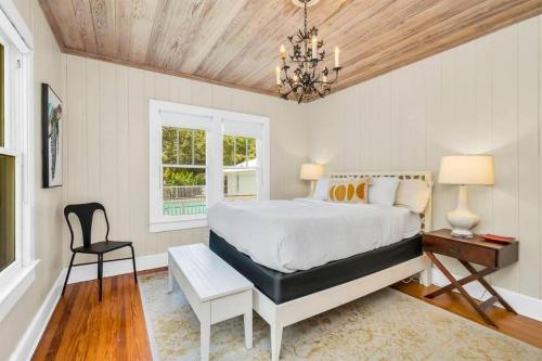 a bedroom with a bed and a chair and a chandelier at Cabin Style Pool Home w/ Guesthouse! Sleeps 10! in Stuart