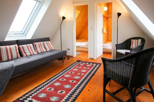 a living room with a couch and chairs and a rug at Alter Bahnhof Bresewitz in Bresewitz