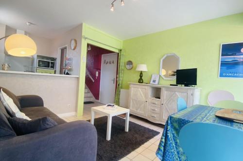 un salon avec un canapé et une table dans l'établissement 42m with 2 balconies near beach and center, à Arcachon