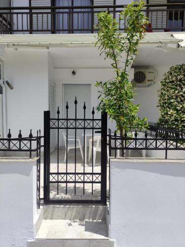 a black gate in front of a white house at White coral 2 in Paralia Katerinis