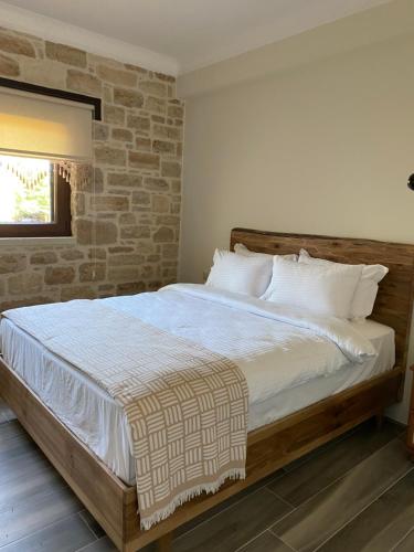 a bed in a bedroom with a brick wall at MERYEM HANIM BUTİK OTEL in Fatsa