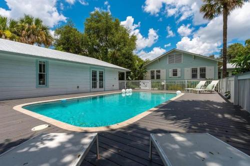 a swimming pool on a deck next to a house at Cabin Style Pool Home w/ Guesthouse! Sleeps 10! in Stuart