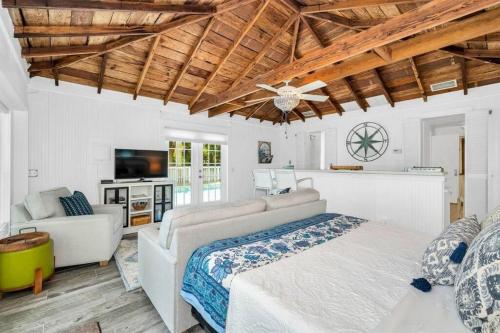 a bedroom with a bed and a couch and a tv at Cabin Style Pool Home w/ Guesthouse! Sleeps 10! in Stuart