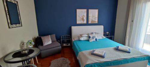 een blauwe slaapkamer met een bed en een stoel bij Apartmani Niko Drašnice in Drašnice