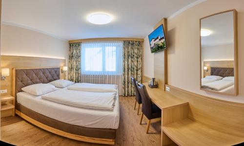 ザルツブルクにあるHotel Ganslhof - Adults onlyのベッドとデスクが備わるホテルルームです。