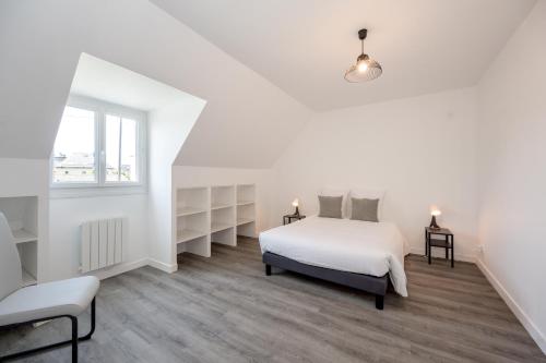 ein weißes Schlafzimmer mit einem Bett und einem Fenster in der Unterkunft La Flora - Charmante maison avec jardin in Pléneuf-Val-André