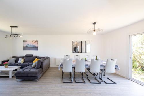 un salon avec un canapé, une table et des chaises dans l'établissement La Flora - Charmante maison avec jardin, à Pléneuf-Val-André