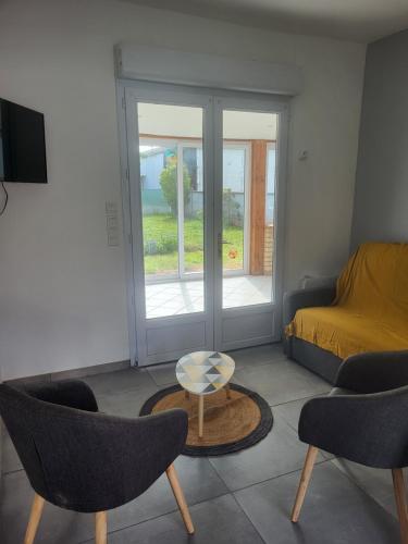 un salon avec un lit, une table et des chaises dans l'établissement GITE 4-6 Personnes proche gare TGV Haute Picardie, à Dompierre-Becquincourt