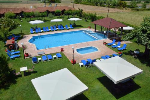 an overhead view of a swimming pool with tables and chairs at Denis Hotel and Bungalows in Korinós