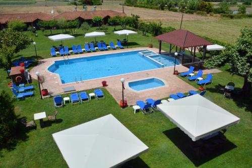 - une vue sur la piscine dotée de tables et de chaises dans l'établissement Denis Hotel and Bungalows, à Korinos