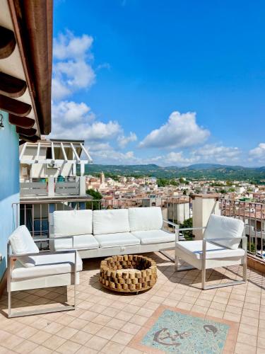 ein weißes Sofa und zwei Stühle auf dem Balkon in der Unterkunft Apartments MADEJ 3 in Bari Sardo