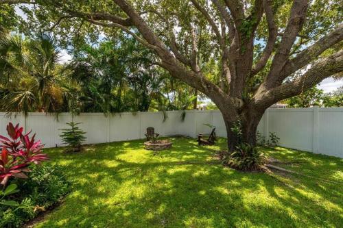 a yard with a tree and a fence at Cabin Style Pool Home w/ Guesthouse! Sleeps 10! in Stuart