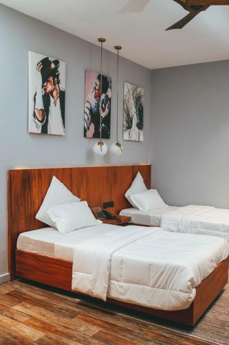 two beds sitting next to each other in a bedroom at Burundi Palace Boutique Hotel in Bujumbura