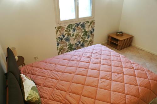 - une chambre avec un grand lit rose et une fenêtre dans l'établissement CHEZ NOUCETTE, à Saint-Cyr-sur-Mer