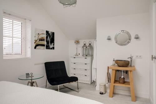 - une chambre avec un lit, une chaise et une table dans l'établissement Schitterende Water Loft hartje centrum Harderwijk, à Harderwijk
