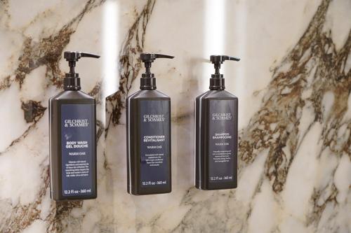 3 Shampoo-Flaschen auf einer Marmortheke in der Unterkunft Sheraton Lake Como Hotel in Como