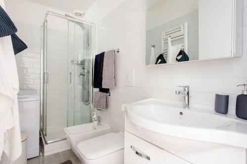 ein weißes Bad mit einem Waschbecken und einer Dusche in der Unterkunft La casa sull'isola in Rom