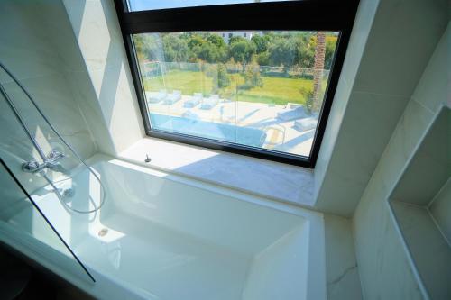 派亞的住宿－Luxury 4 Bedroom Oasis Villa，浴室设有水槽旁的窗户