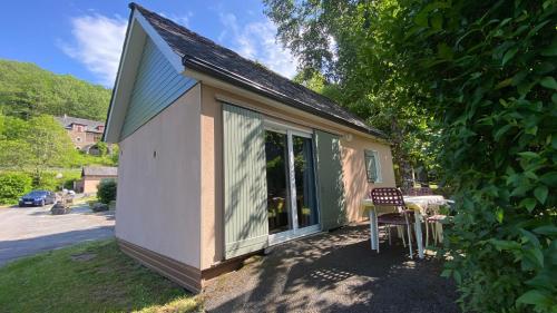 a small house with a table and chairs outside at Village 17 gites, Piscine, Restaurant , 2 gites avec SPA, 3km de Conques in Conques