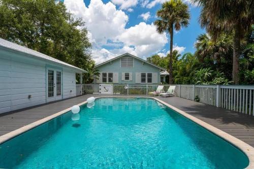 a swimming pool in front of a house at Cabin Style Pool Home w/ Guesthouse! Sleeps 10! in Stuart