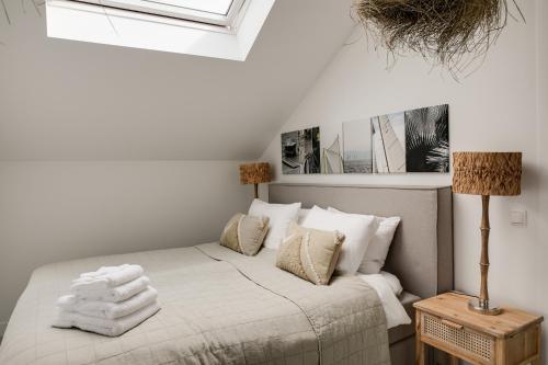 a bedroom with a bed with white sheets and pillows at Schitterende Water Loft hartje centrum Harderwijk in Harderwijk