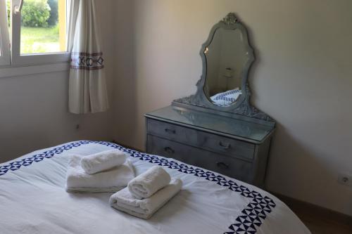 1 dormitorio con tocador y 2 toallas en una cama en Nucleo del area metropolitana-Vigo Dos habitaciones con cama de 150, en Mos
