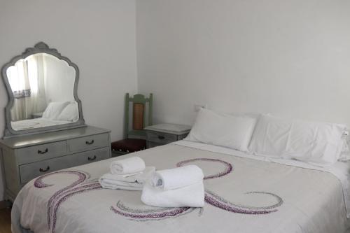 a bedroom with a bed with towels and a mirror at Vixía do Val, "Eclectic" in Mos