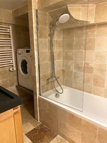 une salle de bain avec baignoire et machine à laver dans l'établissement Maison domaine Golf Country Club de St-Tropez, à Saint-Tropez