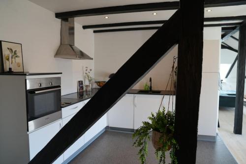 a kitchen with white cabinets and a stove top oven at Penthouselejlighed midt i Vejle in Vejle