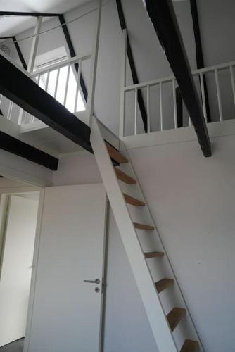 a spiral staircase in a room with white ceilings at Penthouselejlighed midt i Vejle in Vejle