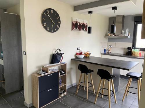 une cuisine avec un comptoir et une horloge au mur dans l'établissement Maison à Pont-Croix, à Pont-Croix