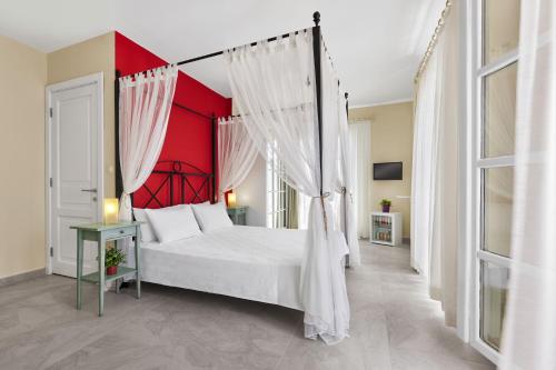 アラカティにあるパンダ アラチャティ ホテルの赤い壁のベッドルーム1室(天蓋付きベッド1台付)