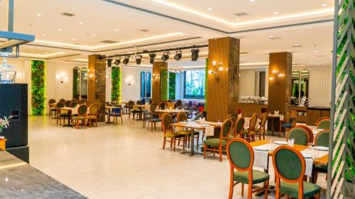 um restaurante com mesas e cadeiras num quarto em Grand Midway Hotel em Baku