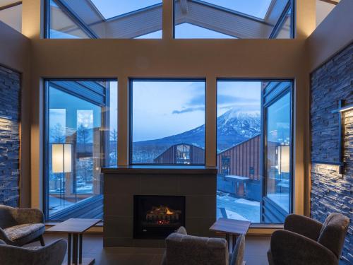 a living room with a fireplace and a mountain view at Panorama Niseko in Kutchan