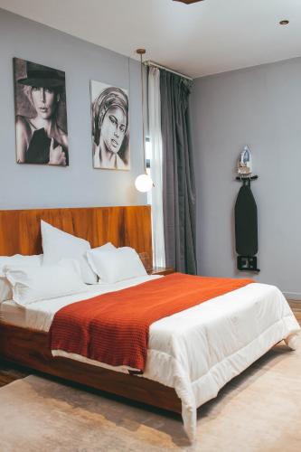 a bedroom with a large bed with posters on the wall at Burundi Palace Boutique Hotel in Bujumbura