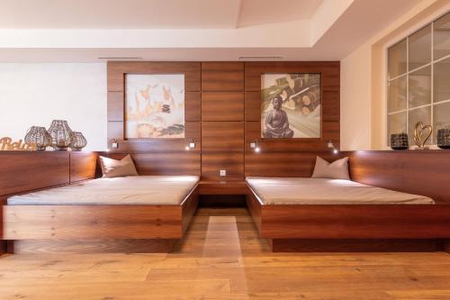 two beds in a room with wooden walls at Hotel Castel - pure Lebensfreude in Serfaus