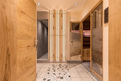 pasillo con puerta de madera y suelo de baldosa en Hotel Castel - pure Lebensfreude, en Serfaus