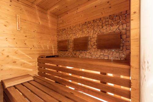 a sauna with wood paneling and a stone wall at Hotel Castel - pure Lebensfreude in Serfaus