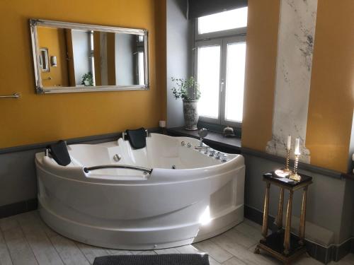 a large white tub in a bathroom with a mirror at Strand Hotel in Norrköping