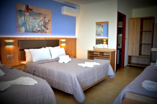 Habitación de hotel con 2 camas y toallas. en Denis Hotel and Bungalows, en Korinós