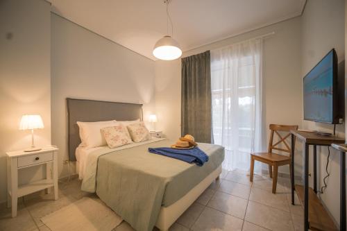 una camera con letto, scrivania e TV di Barbati Bay Elegant Beach Apartments by Hotelius a Barbati