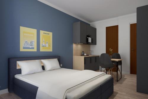 1 dormitorio con 1 cama grande y cocina en Antares Apartments, en Düsseldorf