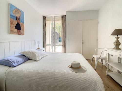 une chambre avec un lit avec un chapeau dessus dans l'établissement Latitude 43-Apartment-Saint-tropez-tennis, à Saint-Tropez