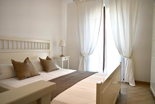 a white bedroom with a large bed with a window at Conero Casa - Marcelli di Numana in Piazzale Eolie 7 in Marcelli