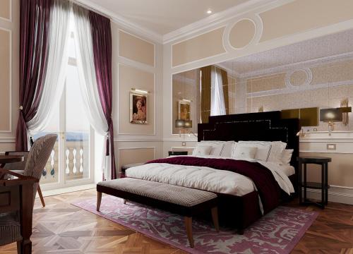 a bedroom with a large bed and a table at Grand Hotel Des Etrangers in Siracusa