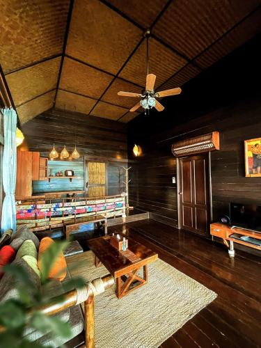 a living room with a couch and a ceiling fan at Koh Tao Cabana in Koh Tao