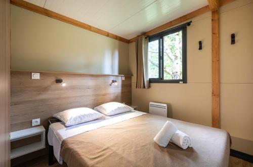 a bedroom with a large bed with two pillows at Huttopia Saumur in Saumur