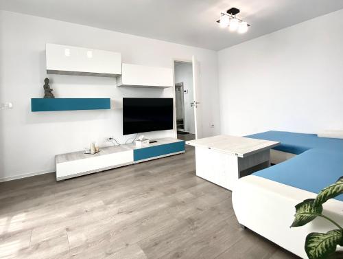 Cette chambre blanche dispose d'un lit et d'une télévision. dans l'établissement Astoria Apartment - Pet Friendly, à Braşov
